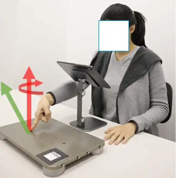 A woman sitting at a workstation using a haptic device for her project