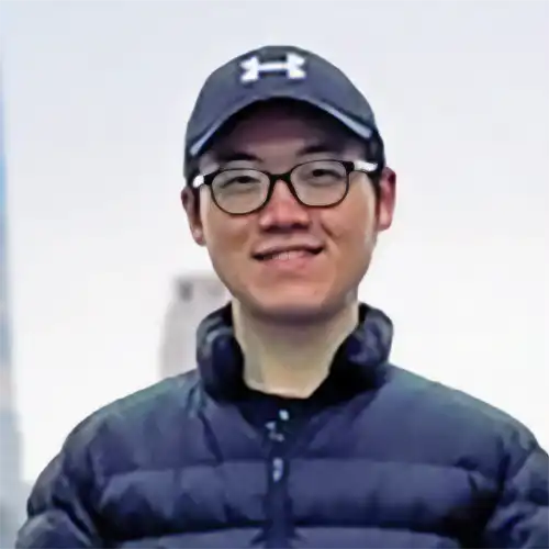 A headshot of Jiachen-paul-Jiang standing in front of some large buildings.