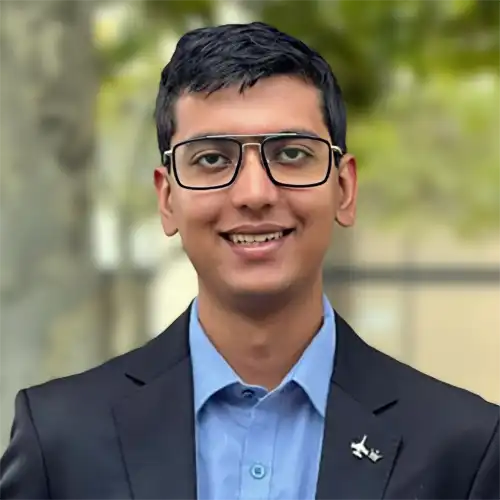 A headshot of Nitya Ranjan standing in front of a large tree.