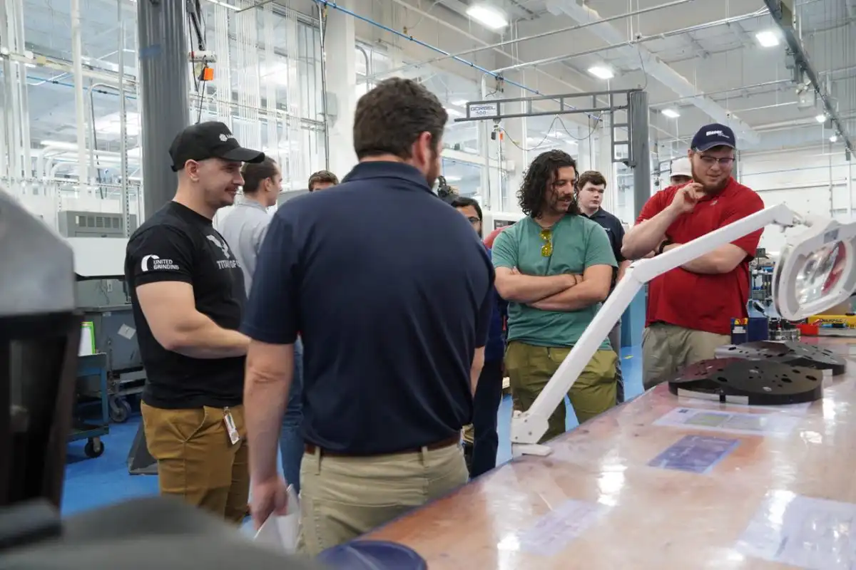 a group f students inside lab looking at a machine