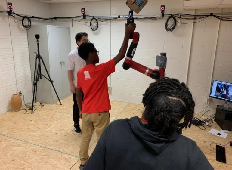 Outreach activities with students from Imhotep Academy experiencing including testing robots.