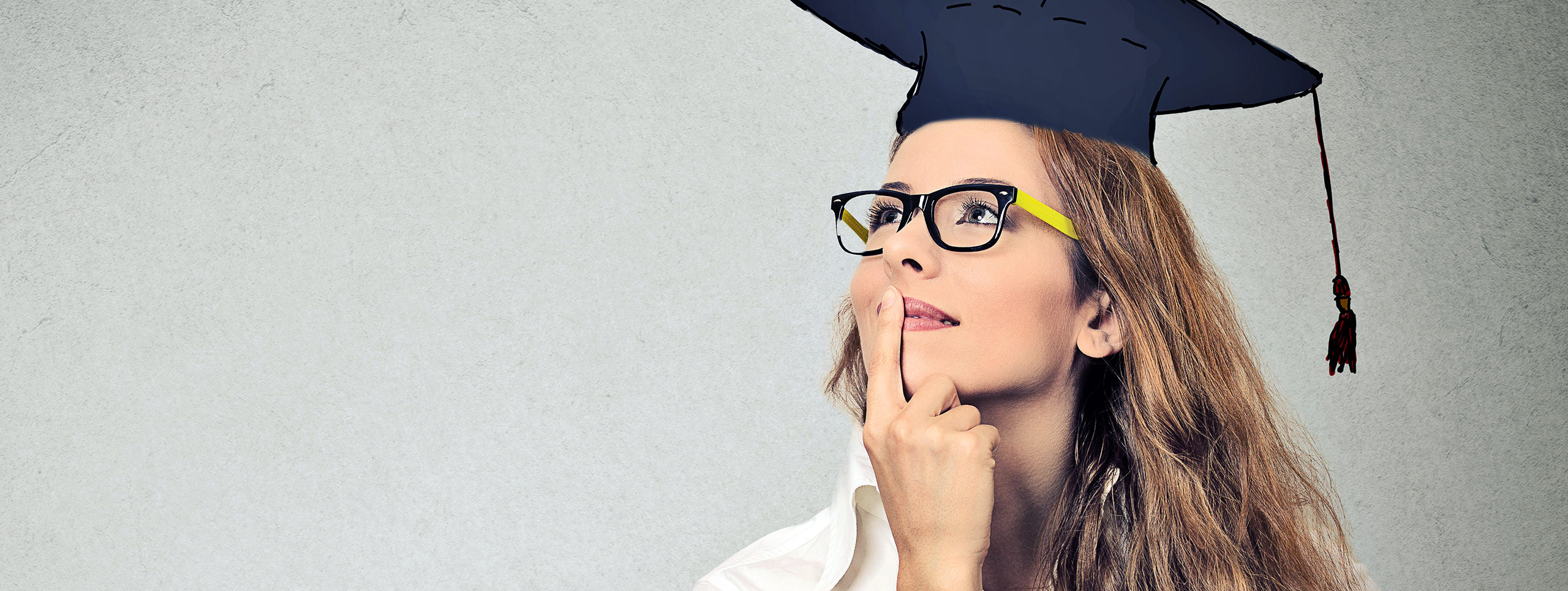 A young women wearing a a graduation cap is pondering her future.