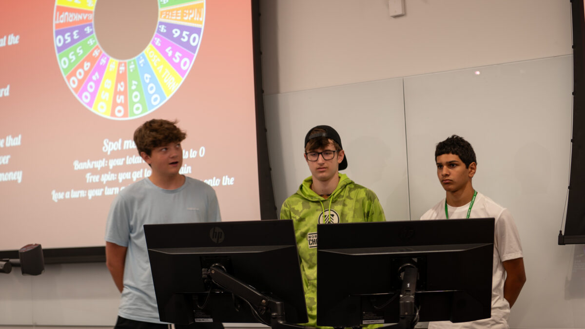 Members of Team Wheel of Fortunopoly explaining the details of their project.