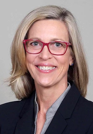 A headshot of Sheila Benny standing in front of a gray background