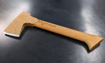 An axe constructed of peanut butter and epoxy lying on a table.