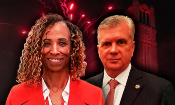 A headshot of Tracy Doaks and Patrick Murray standing in front of the NC State Belltower as red fireworks go off casting a red grow over both people.