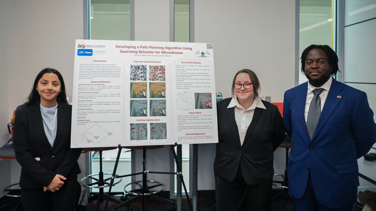 Team Niosh stands next to their senior design poster