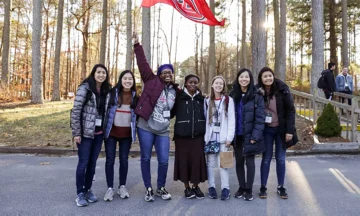 Tabitha Gardner standing in the middle of six of her friends poses for group photo.