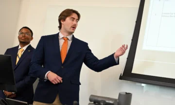 Two students standing at the front of the class presenting the project.